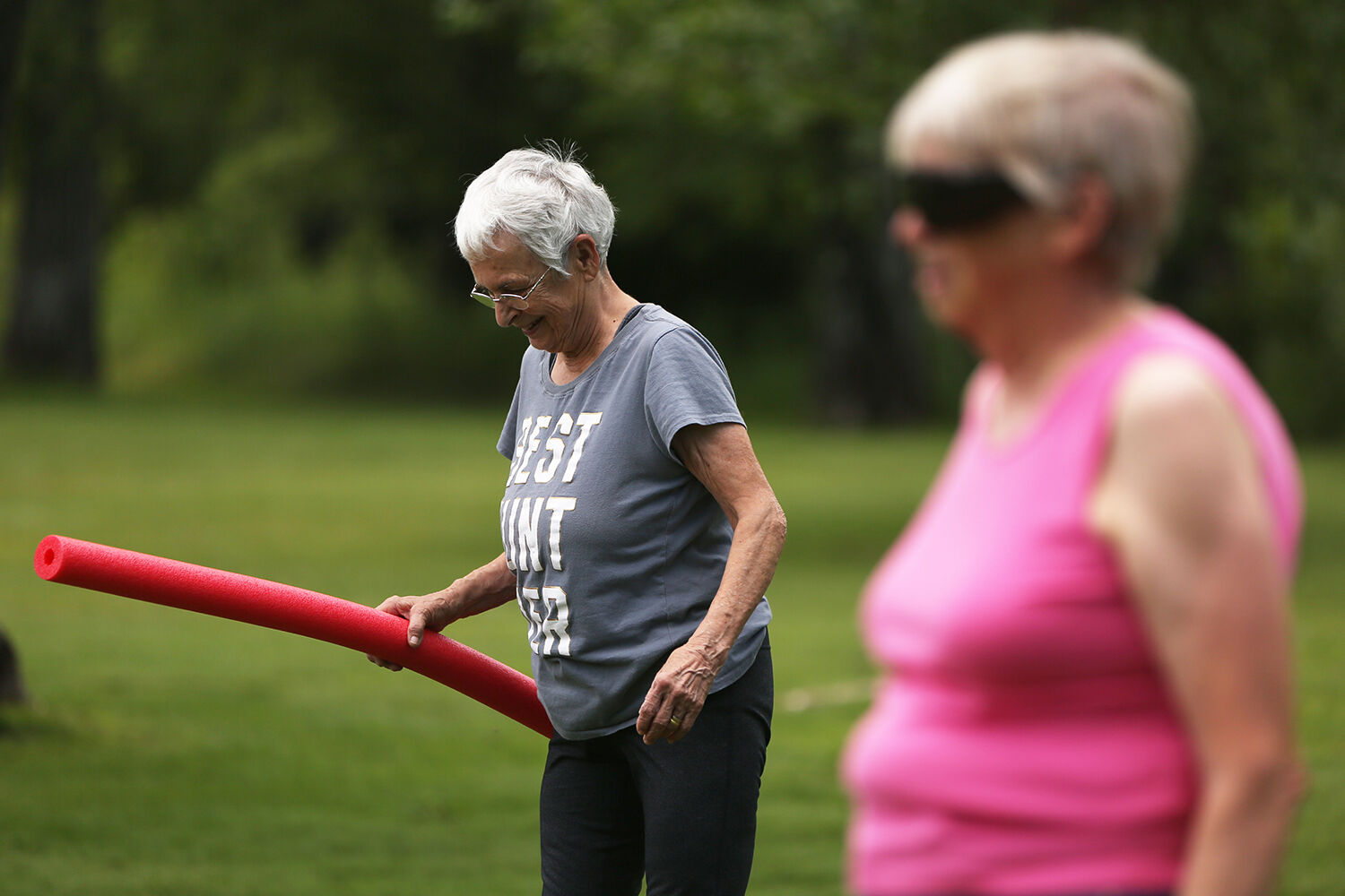 Kay McCormick laughs while walking forward toe to heel during the senior workout class